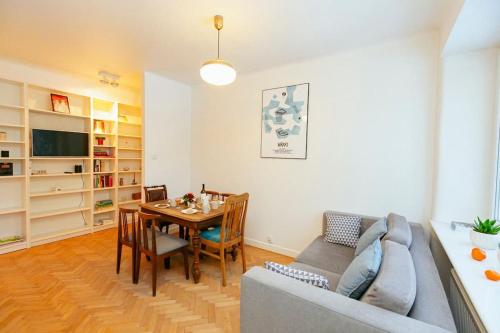 sala de estar con sofá y mesa de comedor en Bright and elegant apartment in the green area!, en Varsovia