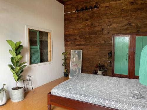 邦美蜀的住宿－Cọ Cùn homestay/Handmade/Artwork，卧室配有一张床铺,位于带木墙的房间内