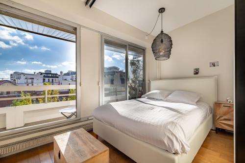 une chambre avec un lit et une grande fenêtre dans l'établissement Veeve - Sky Reach Serendipity, à Paris