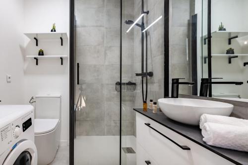 une salle de bain avec un lavabo et une machine à laver dans l'établissement Veeve - Sky Reach Serendipity, à Paris