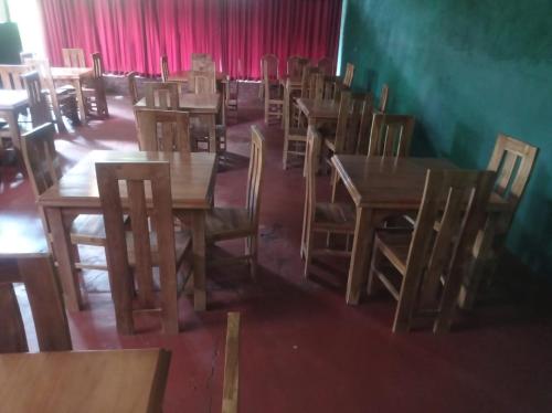an empty restaurant with wooden tables and chairs at Senanayaka Holiday Inn in Polonnaruwa