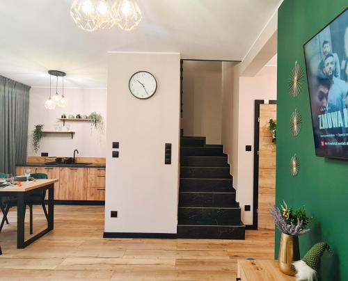 a room with a staircase and a clock on the wall at LEŚNA STODOŁA in Łubiana