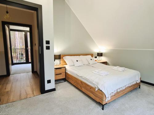 a bedroom with a large bed with white sheets at LEŚNA STODOŁA in Łubiana
