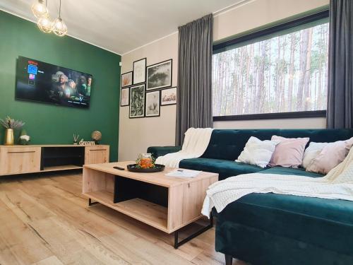 a living room with a couch and a table at LEŚNA STODOŁA in Łubiana