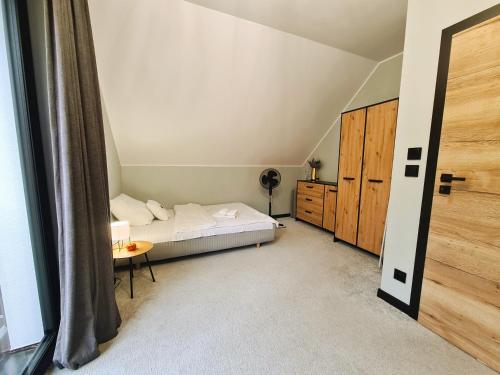 a small bedroom with a bed and a table at LEŚNA STODOŁA in Łubiana