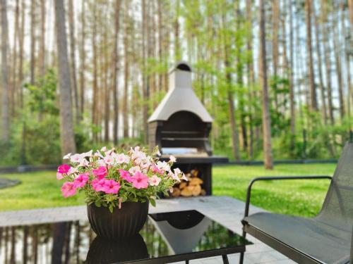 a flower pot sitting on a porch with a fireplace at LEŚNA STODOŁA in Łubiana