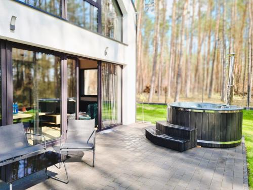 a patio with a hot tub and a table and chairs at LEŚNA STODOŁA in Łubiana
