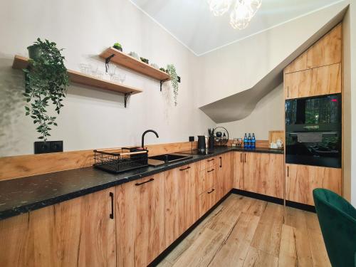a kitchen with wooden cabinets and a black counter top at LEŚNA STODOŁA in Łubiana