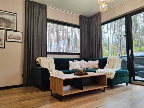 a living room with a green couch and a coffee table at LEŚNA STODOŁA in Łubiana