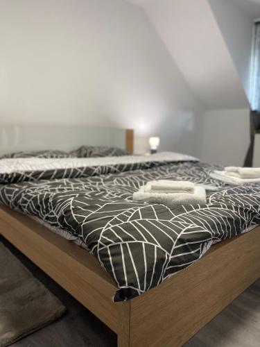 a bed with a black and white comforter on it at Sunny Hill Apartments in Sînpetru