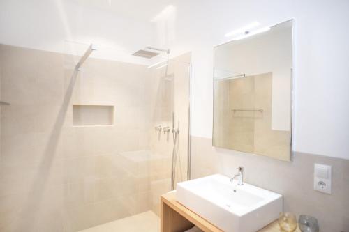 a white bathroom with a sink and a shower at Dorfweber Wohnung Drei in Lagundo