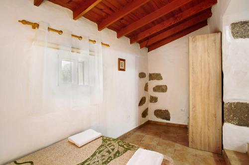 a room with a bed and a wooden door at Vv Casa Frasquita in San Bartolomé de Tirajana