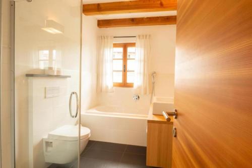 ein Badezimmer mit einem WC und einer Badewanne in der Unterkunft Dorfweber Wohnung Eins in Algund