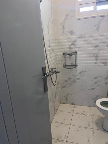 bagno bianco con servizi igienici e porta di شقة مميزه a Muhayil