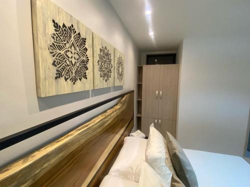 a bedroom with a bed with a wooden headboard at Maidy Luxury in Medellín