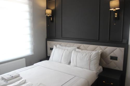 a bedroom with a bed with white sheets and pillows at Cosy Suite in Antalya