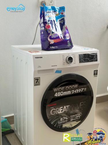 a washing machine with a bag on top of it at Amber Cove Impression City By Heystay Management in Melaka
