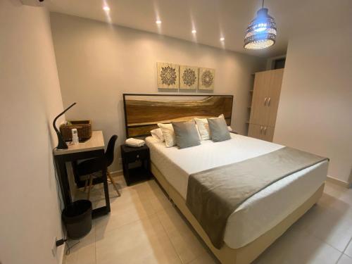 a bedroom with a bed and a table and a desk at Maidy Luxury in Medellín