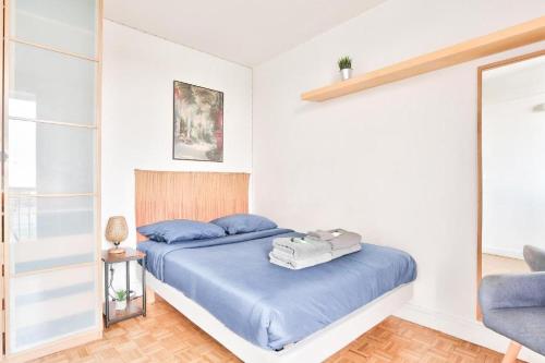 a bedroom with a bed with blue sheets and a chair at BEL APPARTEMENT PARISIEN PARC MONTSOURIS in Paris
