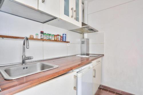 a kitchen with white cabinets and a sink at BEL APPARTEMENT PARISIEN PARC MONTSOURIS in Paris