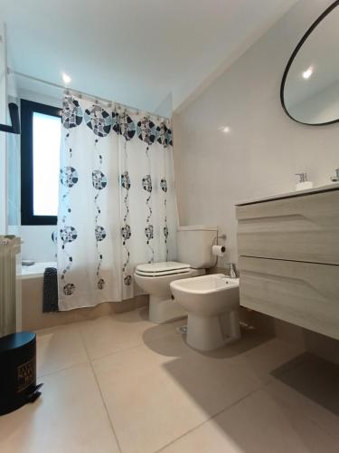 een witte badkamer met een toilet en een wastafel bij Valle Serrano II Departamentos in Tandil