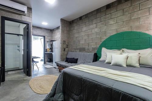 1 dormitorio con 1 cama grande y cabecero verde en Kazuo520 - Studios Industriais Confort en Londrina