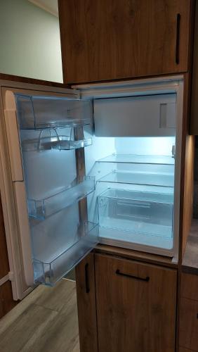 an empty refrigerator with its door open in a kitchen at Apartament Temisto in Bydgoszcz