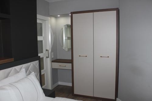 ein Schlafzimmer mit einem weißen Schrank und einem weißen Bett in der Unterkunft Cosy suites hotel in Antalya
