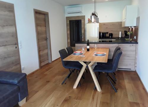 a kitchen and dining room with a wooden table and chairs at Apartment Kristall Real in Bad Radkersburg