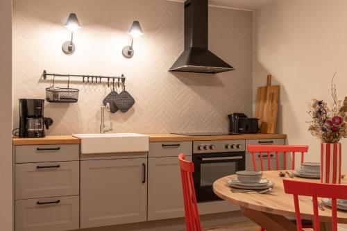 a kitchen with a sink and a stove and a table at Ferienwohnungen Bockstraße in Quedlinburg