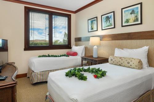 a hotel room with two beds with flowers on them at Ko Olina Beach Villas O505 in Kapolei