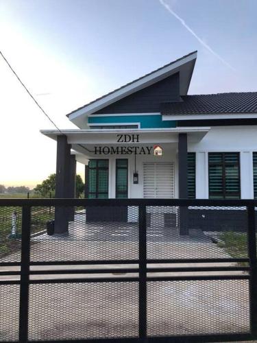 a house with a fence in front of it at ZDH Homestay in Kota Bharu