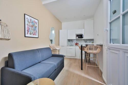 un salon avec un canapé bleu et une cuisine dans l'établissement 0#Appart 4Pers#1 Bedroom#Paris 15#Commerce#AC, à Paris