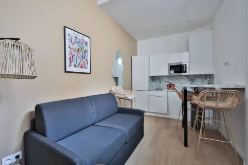 un salon avec un canapé bleu et une cuisine dans l'établissement 0#Appart 4Pers#1 Bedroom#Paris 15#Commerce#AC, à Paris