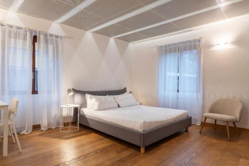 ミラノにあるeasyhomes - Spiga Suiteのベッドルーム1室(ベッド1台、テーブル、椅子付)