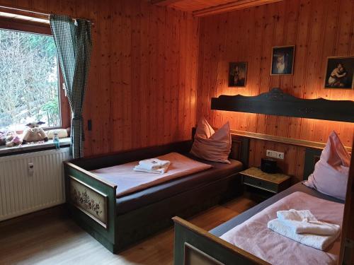 two beds in a room with a window and a bedvisor at Uriges Apartment + Schönblick + mitten im Bayerischen Wald + WLAN kostenfrei in Schöfweg