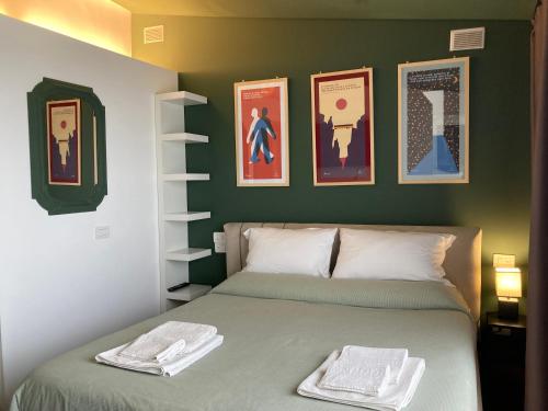 una camera con un letto e alcune immagini sul muro di Le Petit Palais - Naples a Napoli