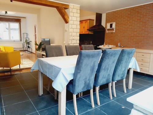 a kitchen with a table and blue chairs at Evere home - Private room in Brussels