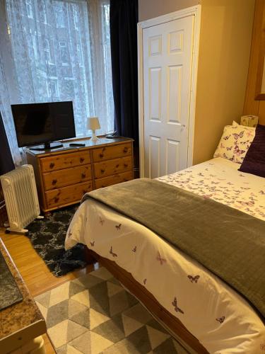 a bedroom with a bed and a tv on a dresser at ROOM with SHOWER, TOILET and KITCHENETTE in Tonbridge