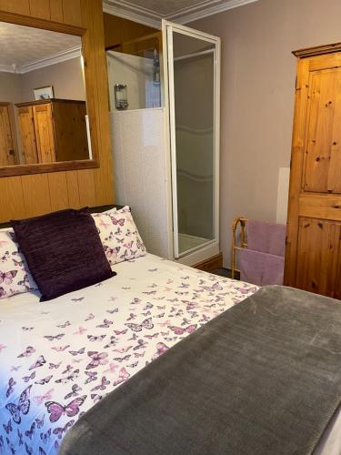 a bedroom with a bed and a glass door with a shower at ROOM with SHOWER, TOILET and KITCHENETTE in Tonbridge