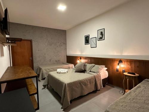 a hotel room with two beds and a table at Hotel Morro De Santo Agostinho in Serra Negra