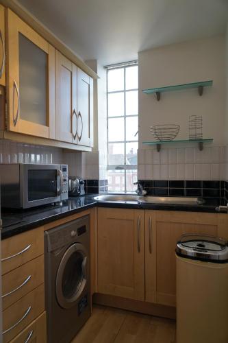 cocina con lavadora y microondas en One Bedroom in Chelsea en Londres