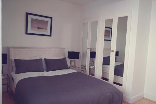 a bedroom with a bed and two mirrors at One Bedroom in Chelsea in London