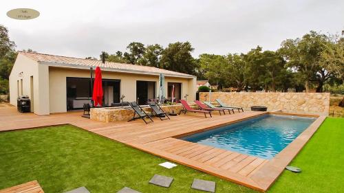 une arrière-cour avec une piscine, des chaises et une maison dans l'établissement Villa U Scopu, 6 pers, piscine chauffée, 10 mn plage en voiture, à Lecci
