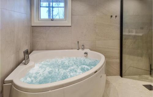 a bathroom with a bath tub with a window at Amazing Home In seral With House A Mountain View in Åseral