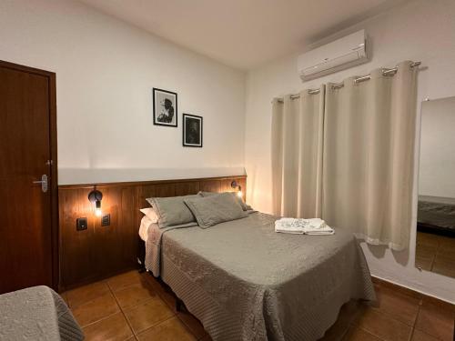 a bedroom with a bed and a window at Hotel Morro De Santo Agostinho in Serra Negra