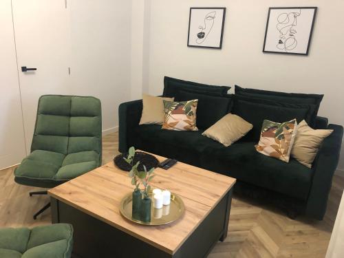 a living room with a green couch and a coffee table at Apartament Frezja in Gryfów Śląski