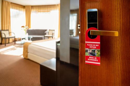 a hotel room door with a sign on it at Europe Hotel in Sofia