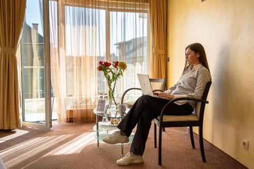a woman sitting in a chair with a laptop at Europe Hotel in Sofia