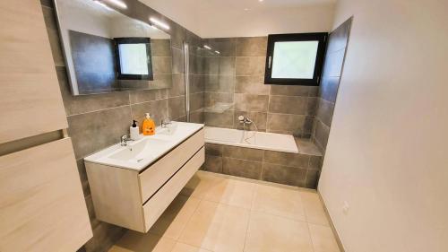 une salle de bain avec un lavabo et une baignoire dans l'établissement Villa Silvio, 8 pers, piscine, 15 minutes plage en voiture, à Sainte-Lucie de Porto-Vecchio